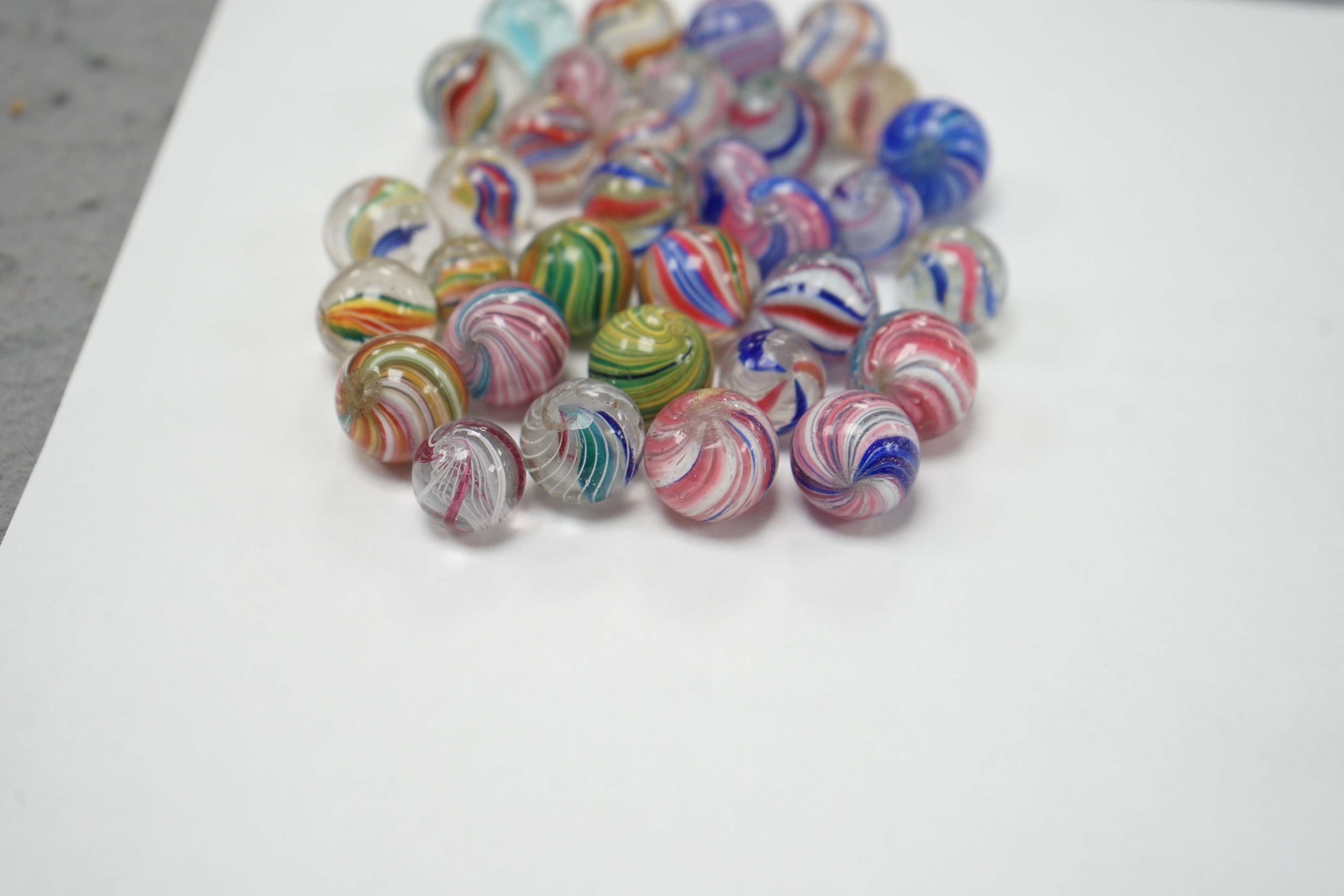 A mahogany solitaire board with a collection of latticino and marbled glass marbles